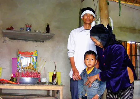 Anh Nguyễn Sỹ Cường (xóm Đăng Lưu) và con trai trước bàn thờ vợ, mẹ Nguyễn Thị Quyền.