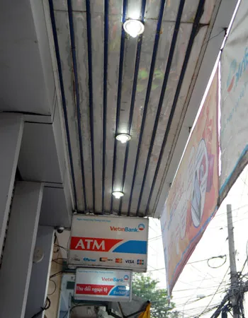 Hàng loạt đèn vẫn chiếu sáng gây lãng phí điện. Ảnh chụp lúc 7 giờ ngày 5-4, phía trước Phòng giao dịch số 3, Chi nhánh 5 ViettinBank. Ảnh: Kim Ngân