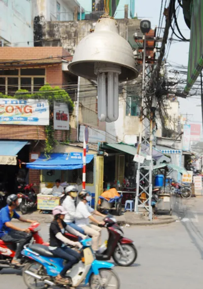 Sử dụng đèn compact chiếu sáng một con hẻm trên đường Nguyễn Biểu. Ảnh: KIM NGÂN