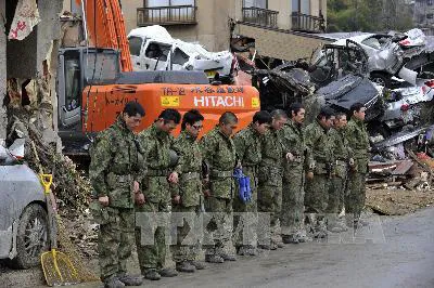 Binh sĩ Nhật Bản dành một phút im lặng để tưởng niệm các nạn nhân của trận động đất sóng thần ở Kesennuma, tỉnh Miyagi. Ảnh: AFP-TTXVN