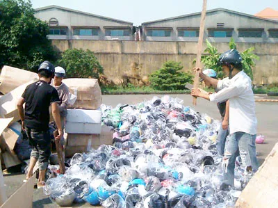 Tiêu hủy nón bảo hiểm kém chất lượng. Ảnh: T.H.