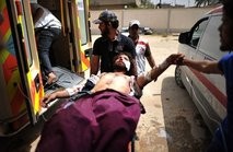 A Libyan rebel is wheeled into an ambulance after being wounded by a mortar shell which killed two rebels
