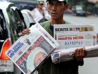 AFP - A newspaper seller offers a daily paper with the headline reading "The end of Osama" to motorists in Jakarta on May 3, 2011.
