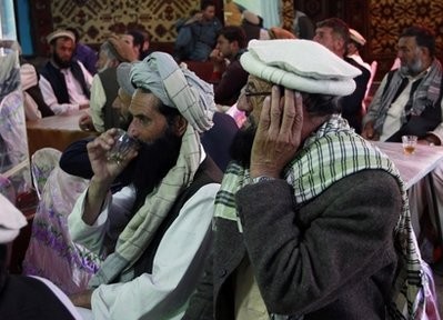 Afghan men gathered to watch television coverage announcing the killing of Al-Qaida leader Osama bin Laden a few minutes before the start of news service on a local TV channel at a local restaurant in Kabul, Afghanistan Monday, May 2, 2011