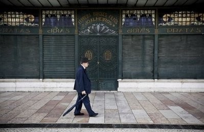 A man passes in front of a closed-down jewellery shop in Lisbon.