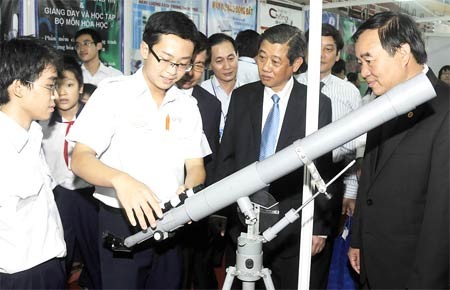 Pupils from Tran Dai Nghia High School in District 1, HCMC displaying a refracting telescope made by them, at the festival (Photo: SGGP)