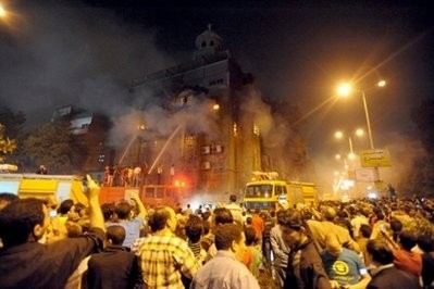 Egyptians watch as firefighters battle a blaze in a church after clashes between Muslims and Christians in Cairo
