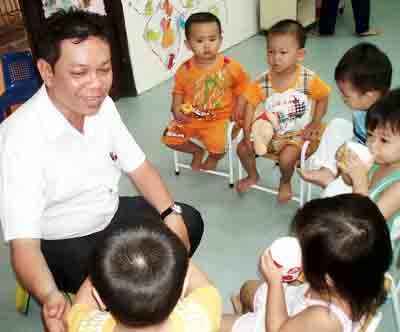 Teacher Nguyen Thanh Luong takes care of small pupils at his nursery (Photo: SGGP)