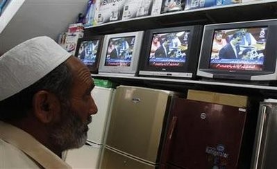 A man watches Pakistan's Prime Minister Yusuf Raza Gilani on a televised address to the parliament at an appliance store in Islamabad, May 9, 2011
