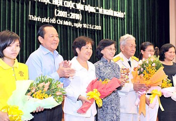 Outstanding individuals were presented with flowers at a ceremony to assess ten years of campaign to alleviate poverty in HCMC on May 10 (Photo: SGGP)