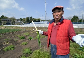AFP - This photo taken on May 4, 0211 shows Japanese farmer Magoichi Shigihara speaking to an AFP reporter as he dumps spinach at his farm in Nihonmatsu in Fukushima prefecture