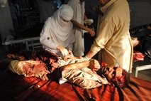 Hospital staff members treat a person injured in twin suicide bomb attacks, at a local hospital in Peshawar