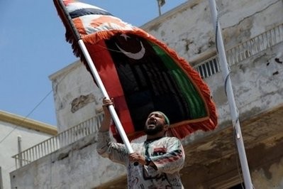 A man waves the flag of the Libyan revolution during a Friday noon prayer rally in Benghazi.