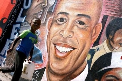 A boy walks by a mural of president-elect Michel Martelly in Port-au-Prince on