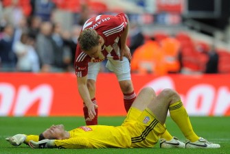 AFP - Stoke's English footballer Ryan Shawcross (Top) consoles team-mate and goalkeeper Thomas Sorenson after losing to Manchester City 0-1
