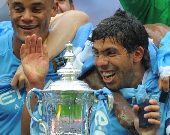 AFP - Manchester City's Argentinian footballer Carlos Tevez (R) celebrates with the FA Cup after his team beat Stoke 1-0