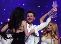 AFP - Last years winner Lena (L) of Germany hands the trophy to Eldar Kasimov and Nigyar Djamal