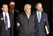 IMF head Dominique Strauss-Kahn (C) leaves a police station in New York in handcuffs on May 15
