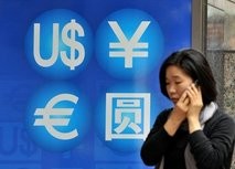 woman walks past a money exchange sign in Seoul. The euro has fallen half a cent in opening Asian trade