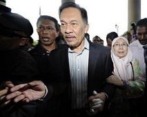 Malaysia's opposition leader Anwar Ibrahim (C) and wife Wan Azizah Wan Ismail arrive at the courthouse