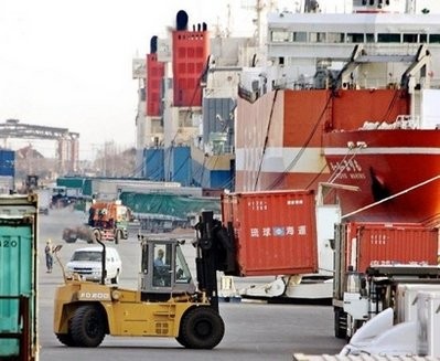 Longshoremen unload containers from at a port in Tokyo