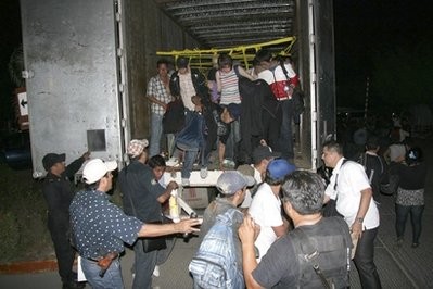 In this photo released by Chiapas State Attorney General, migrants from Latin America and Asia leave a truck that was heading to the US after being detected by an X-ray equipment at a checkpoint near Tuxtla Gutierrez, in Mexico's southern Chiapas state, Tuesday, May 17, 2011