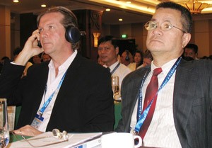 Anthony Van Dam (L), vice president of Canadian company Forrec, adjusts his headphone while Nguyen Thanh Tuan (R), managing director of Vietlink Consulting, listens at the conference (Photo: Tuong Thuy)