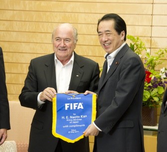 AFP - Japan's Prime Minister Naoto Kan (R) holds a complimentary FIFA banner presented by FIFA President, Joseph Blatter (L) prior to their talks at Kan's official residence in Tokyo on 23 May, 2011.