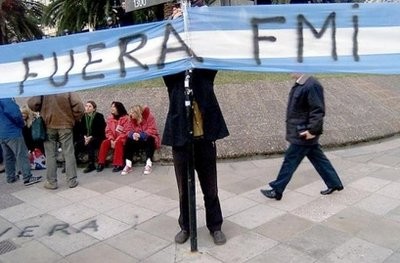File photo shows a protestor adjusting an anti-IMF banner during a rally against the global financial body in the Argentine capital of Buenos Aires