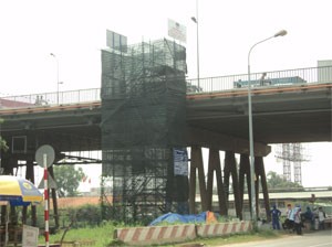 A pole of the Saigon Bridge is fenced off for repairing (Photo:Minh Tri)