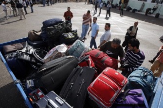 AFP - Palestinians load their luggage as they wait to cross into Egypt through the Rafah border crossing in the southern Gaza Strip on May 28, 2011