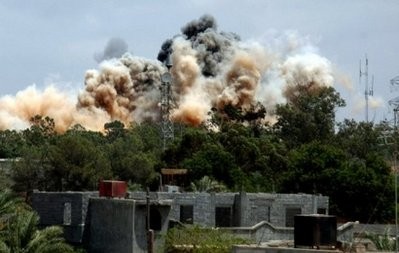 AFP file - Smoke billows behind the trees following an air raid on the area of Tajura, east of Tripoli on May 24.