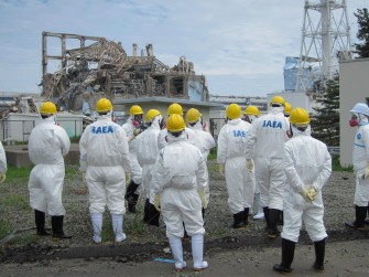 AFP file - This handout picture, taken by Tokyo Electric Power Co (TEPCO) on May 27, 2011, shows International Atomic Energy Agency inspection team members looking at the unit three reactor building of the Fukushima Dai-ichi nuclear power plant