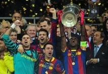 Barcelona's Eric Abidal (R) celebrates with the trophy at the end of the UEFA Champions League final