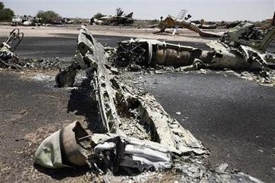A destroyed military jet belonging to government forces is seen at Misrata airport during a patrol by rebel fighters, May 28, 2011.