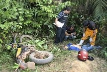 Police officers inspect the dead body of rubber tapper Jose Claudio Ribeiro da Silva in Brazil's Amazon