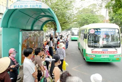 Hành khách tại một trạm chờ xe buýt. Ảnh: KIM NGÂN