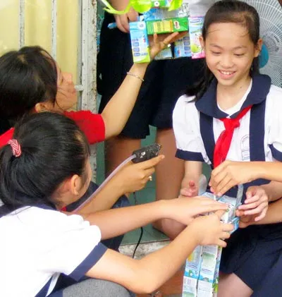 Nhà vô địch nhí Phạm Nhật Phương Trinh (đeo khăn quàng) cùng các bạn làm sản phẩm tái chế tham gia ngày hội môi trường.