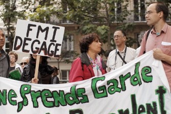 AFP - People, including Spain's and Portugal's nationals demonstrate on June 19, 2011 in Paris, in support of Spain's anti-crisis protesters. Placard (background) reads: "IMF get lost"