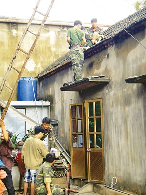 Soldiers help residents to repair their homes after the storm attacked An Lu commune in Hai Phong.(Photo:SGGP)