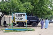 People walk past the main gate of the state police command headquarters in Maiduguri,