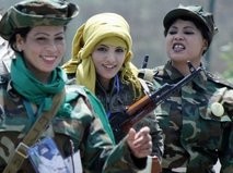 Libyan women and supporters of Libyan leader Moamer Kadhafi wear army fatigues and hold up weapons as they attend a women's forum in Tripoli on June 25, 2011
