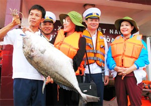 (File) Former Ho Chi Minh City People’s Council chief Ms. Pham Phuong Thao (2nd, L) receives a big fish from soldiers on Alison Reef