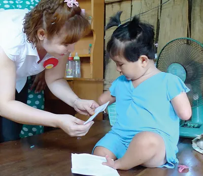 Nữ doanh nhân thăm và tặng quà cháu Nguyễn Hoài Thương, nạn nhân dioxin, sinh năm 2008 tại ấp Cây Sộp, xã Tân An Hội, huyện Củ Chi, TPHCM. Ảnh: QUANG THÁI