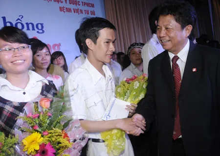 Tổng biên tập báo SGGP Trần Thế Tuyển chúc mừng các sinh viên nhận học bổng Nguyễn Văn Hưởng năm 2011. Ảnh: Mai Hải