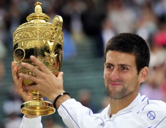 AFP - Novak Djokovic holds the trophy after beating Spanish player Rafael Nadal in the men's single final at the Wimbledon Tennis Championships on July 3, 2011.