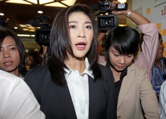 AFP - Yingluck Shinawatra answers a question from the press while walking at Puea Thai party headquarters in Bangkok on July 5, 2011.