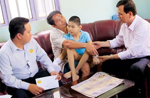 Representatives from Association of Victims of Agent Orange/Dioxin in Cu Chi District meet Phan Thanh Hau (blue), a victim of Agent Orange and his father