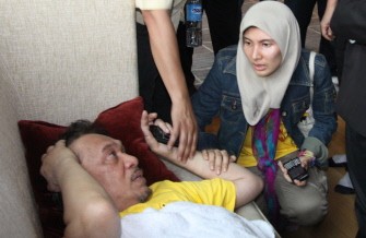 AFP - Malaysian opposition leader Anwar Ibrahim (L) is comforted by his daughter Nurul Izzah (R) after he felt unwell and fell on the pavement following a tear gas attack by police during a mass rally for electoral reform in Kuala Lumpur on July 9, 2011.