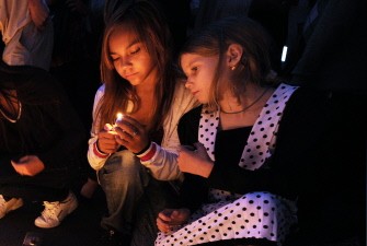 AFP - Little girls light candles in memory of victims of the pleasure boat Bulgaria that sank and killed at least 116 people